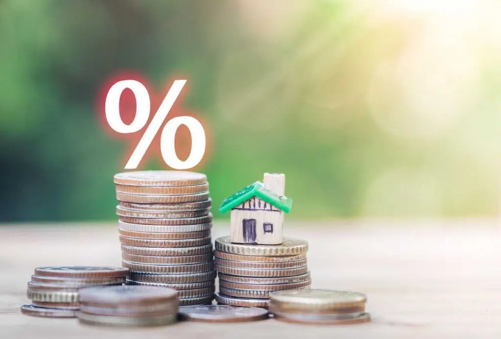 금리(interest rate)의 감소_나무 테이블 위에 집과 동전