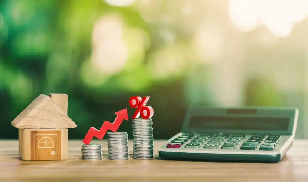 금리(interest rate)의 상승_나무 테이블 위에 집과 동전